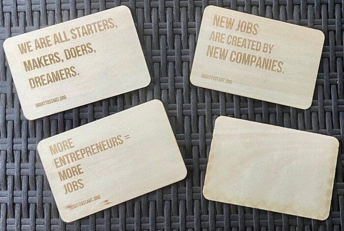 Four wooden plaques display motivational quotes about entrepreneurship and job creation.